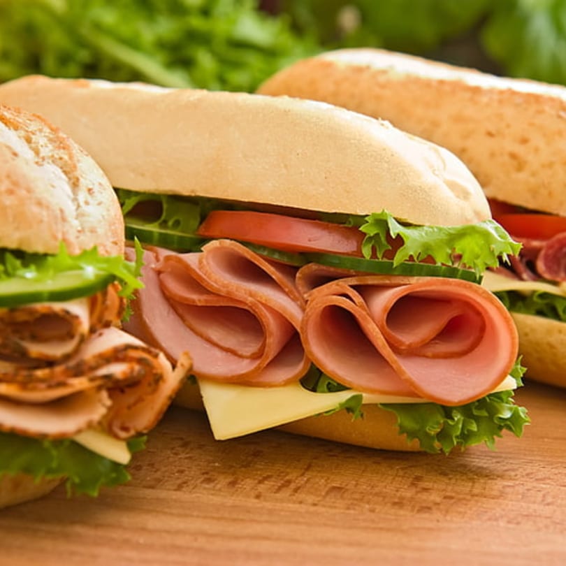 Three fresh Philly's Best subs with ham, turkey, cheese, lettuce, tomato, and cucumber.