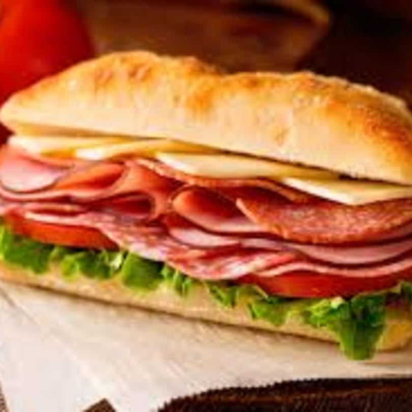 A large Philly's Best sub sandwich filled with deli meats, cheese, lettuce, and tomatoes.
